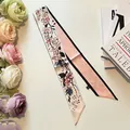 Macro detail of a double-sided floral silk twilly scarf with pink cherry blossoms and black edges - 6x100cm / Light Pink