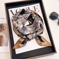 Seidenschal mit Blumenmuster in Senfgelb und Schwarz auf einem Modemagazin serviert - Braun