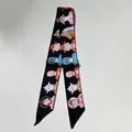 Détail d'un foulard en soie twilly noir avec illustrations pop art colorées et bouts pointus - 80-100cm / Noir