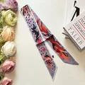 Detail view of a long narrow silk scarf with blue abstract prints and pointed ends - Gray