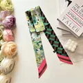 Close-up of double-sided twilly silk scarf with floral and geometric patterns - Green & Brown