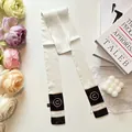 Close-up of elegant black and white twilly silk scarf with letter print and floral decor - White (Rhombus Grid)