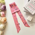 Close-up of pink silk twilly scarf with heart patterns on decorative books background - Pink Heart Letter Style / S796 Pink