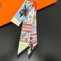 Detail view of artistic printed silk twilly scarf tied on handbag handle for styling - Black