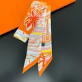 Elegant orange silk scarf with architectural prints on a premium gift packaging background - Orange