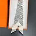 Minimalistischer schwarz-weiß gestreifter Seidenschal in einer luxuriösen orangefarbenen Box - Gebrochenes Weiß