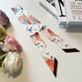 Detailed close-up of decorative silk twilly scarf with elegant mask and tiger patterns - 80-100cm / Beige