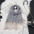 Vue détaillée d'une écharpe en soie gris clair avec perles dorées et bordure brillante - Pack de 10 brins / Gris clair