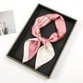 Detailed close-up of pink silk scarf with geometric oil painting print on display tray - Pink