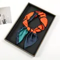 Detail of artistic oil painting print on silky satin scarf tied in a stylish knot - Navy Blue