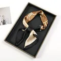 Detailed view of an oil painting graffiti print silk scarf knotted on a black tray - Black