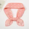Detail of pink chiffon scarf with white polka dot pattern tied in a decorative knot - Snow Bud