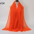 Solid orange pleated cotton linen scarf with frayed edges on a female mannequin - 180x90cm / Orange (#34)