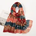 Macro detail of retro floral print and striped patterns on lightweight long shawl fabric - Teal and Orange