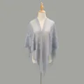 Close-up of light grey-blue lace shawl with floral embroidery and long tassel details - Gray