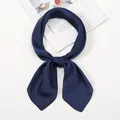 Detalle de un pañuelo de seda sintética azul marino anudado en fondo blanco - Talla única / Azul Marino