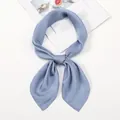 Detail of light blue satin neck scarf tied in a bow on a stylish magazine backdrop - One Size / Denim Blue