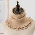 Close-up of khaki knitted neck warmer featuring chunky ribbed texture and ruffled edges - Camel