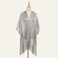 Detail of silver metallic mesh shawl with long fringe tassels on a wooden hanger - Gray