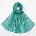 Close-up of lightweight turquoise silk shawl with metallic luster and satin texture - Teal Blue