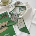 Elegant green twilly silk scarf with geometric star patterns on a white shirt background - Light Green Alphabet Geometric