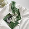 Elegant dark green and white floral skinny scarf tied on a white shirt with a coffee cup - Light Green Vine Floral
