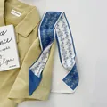 Élégant foulard twilly en soie à fleurs bleu et blanc sur une veste chic - Bleu Guirlande de Fleurs
