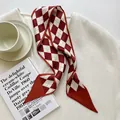 Élégant foulard en soie à damier rouge et blanc présenté sur un tissu blanc texturé - Motif de Diamant Rouge