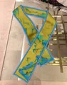 Dettaglio di un foulard in seta twilly con arte paesaggistica cinese su tavolo - Stile Paesaggio Giallo Brillante (Colore 2)