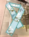 Dettaglio di sciarpa in seta azzurra con stampe di magnolia e calligrafia cinese - Stile Magnolia Blu Chiaro (Colore 3)