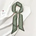 Detail of dark green paisley silk twilly scarf tied on a white silk dress strap - 130x7cm / Dark Green Paisley