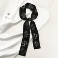 Elegante zwarte twilly zijden sjaal met gouden weegschaal en bloemen op witte jurk - Zwart Goud Bloemig (Abrikoos SKU)