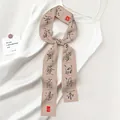 Beige zijden sjaal met zwarte kalligrafie bevestigd aan een witte satijnen band - Beige Calligrafie (Oranje SKU)