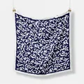 Navy blue silk scarf with white leaf patterns and border hanging on a white wall - Navy Blue Leaf Pattern