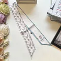 Close-up of narrow silk scarf with black rose patterns and grey blue edge borders - Rose Blossom