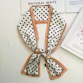 Pañuelo de seda retro con lunares y ribete naranja, anudado en un elegante estilo lazo - Blanco (Borde Naranja)