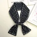 Retro black and white polka dot skinny silk scarf tied in an elegant knot on white books - 80-100cm / Black