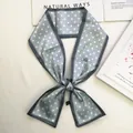 Detail of blue polka dot silk scarf tied on a white surface with minimalist props - 80-100cm / Gray
