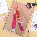 Detailed view of a floral print twilly silk scarf draped over a classic golden picture frame - Burgundy