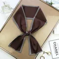 Gros plan d'un foulard en satin marron foncé avec bordures à chevrons noirs et blancs - Style Long / Café Foncé