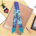Close-up of royal blue twilly scarf with heart and equestrian print on a styled display - Sky Blue
