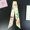 Detailed view of yellow floral skinny twilly scarf on a flat lay textured background - 80-100cm / Yellow