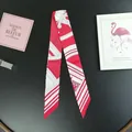 Close-up of red and white polka dot silk twilly scarf with elegant architectural patterns - Red