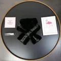 Close-up of black faux fur scarf featuring elegant black and gold tweed detail on tray - Black