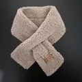 Detailed view of oatmeal faux lamb wool scarf texture and brown leather brand label - 80-100cm / Elegant Camel
