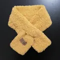 Detalle de bufanda de felpa amarilla con textura suave y etiqueta tejida coreana - Amarillo Noble