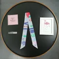 Fashionable grey skinny silk scarf with colorful belt print on a black tray - Gray