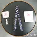 Detail of navy blue silk scarf with white flamingo print used as a bag handle wrap - Navy White Flamingo (S177-19)