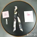 Detail view of a black and white patterned twilly silk scarf for handbag handles - Black White Wheel (S177-21)