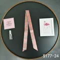 Detailed macro view of pink plaid skinny silk scarf wrapped on a round black tray - Pink Plaid (S177-24)